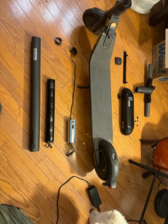 Jacky’s scooter taken apart for repair, with parts arranged on the floor